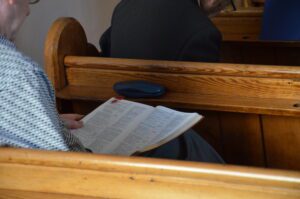 Man sitting in a pew reading the Bible